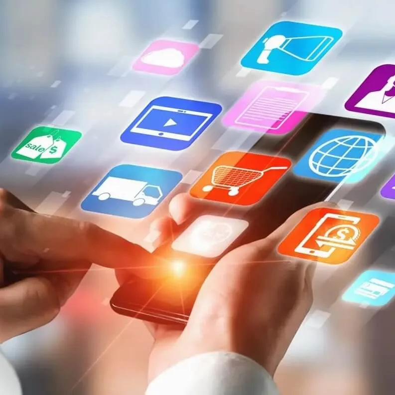 Eine Person tippt auf ein Smartphone, wobei bunte, schwebende digitale Symbole das Gerät umgeben – sie stehen für Multi Channel Messaging.